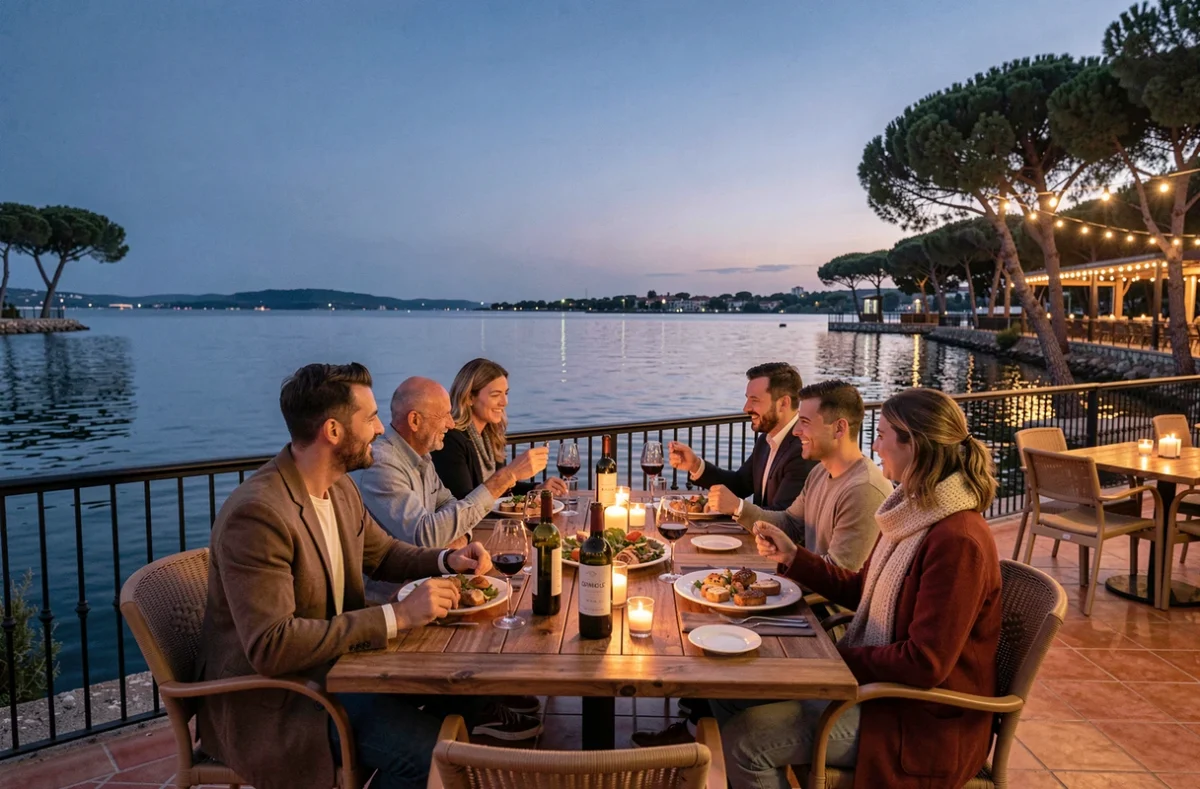 Groupe d'amis profitant d'une soirée estivale en terrasse d'un restaurant au bord du lac de Bordeaux avec vue sur l'eau au crépuscule
